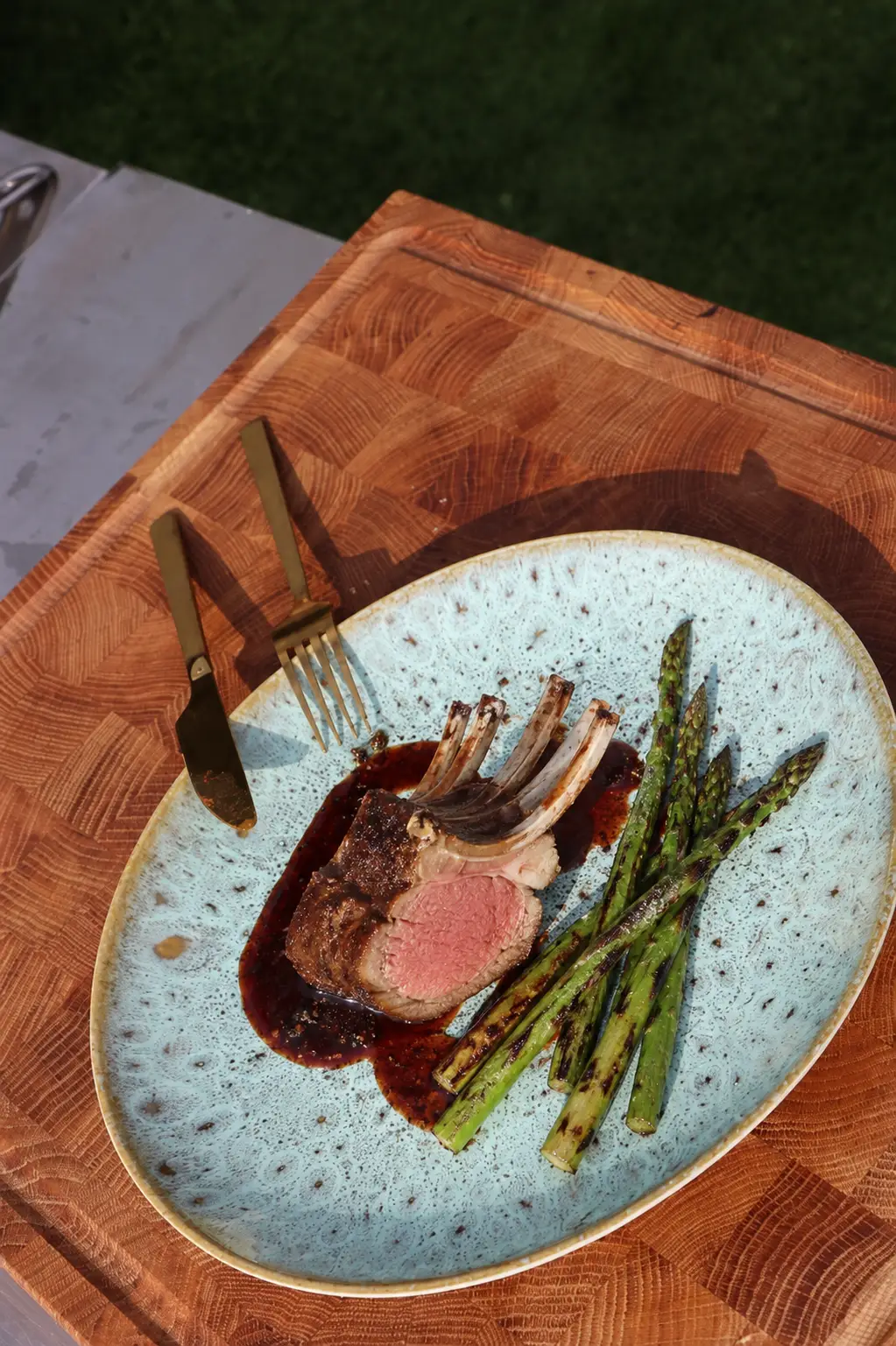 Rosa gebratene Lammkrone mit dunkler Portwein-Feigen-Reduktion und gegrilltem grünem Spargel.