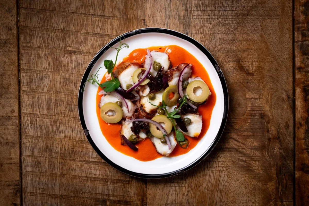 Grill Oktapus 
Gegrillte Oktapus / „Florinis“ Paprika Creme / Oliven / Kapern / Karamelisierte Zwiebeln