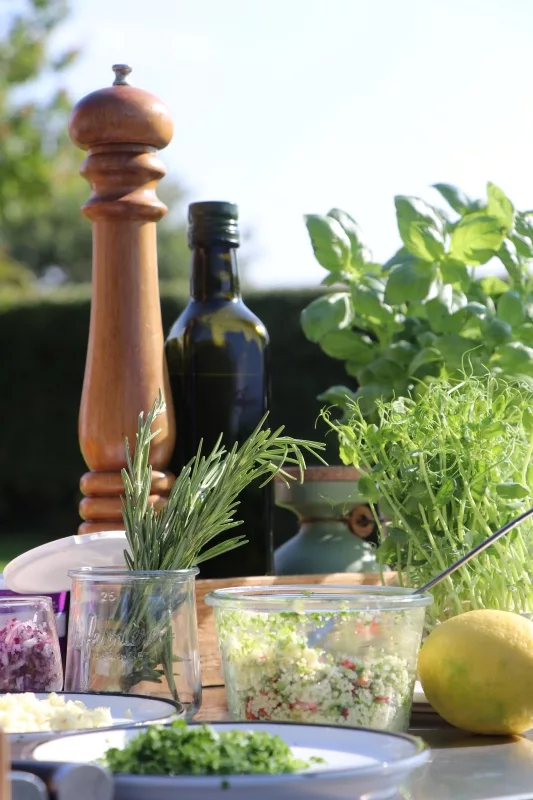 Olivenöl Und Kräuter Hochwertiges natives Olivenöl, eine hölzerne Pfeffermühle und frischer Rosmarin als Basis für das mediterrane Fine Dining.